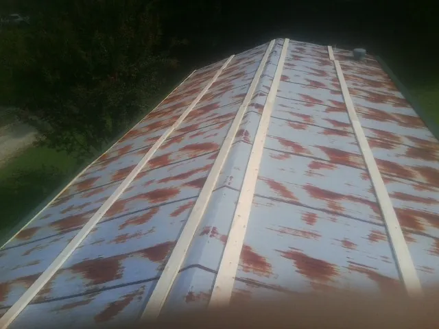Rusted metal roof panels with new wood purlins before replacement — Storm Damage Roof Repair in El Dorado Hills by Roofing Brothers